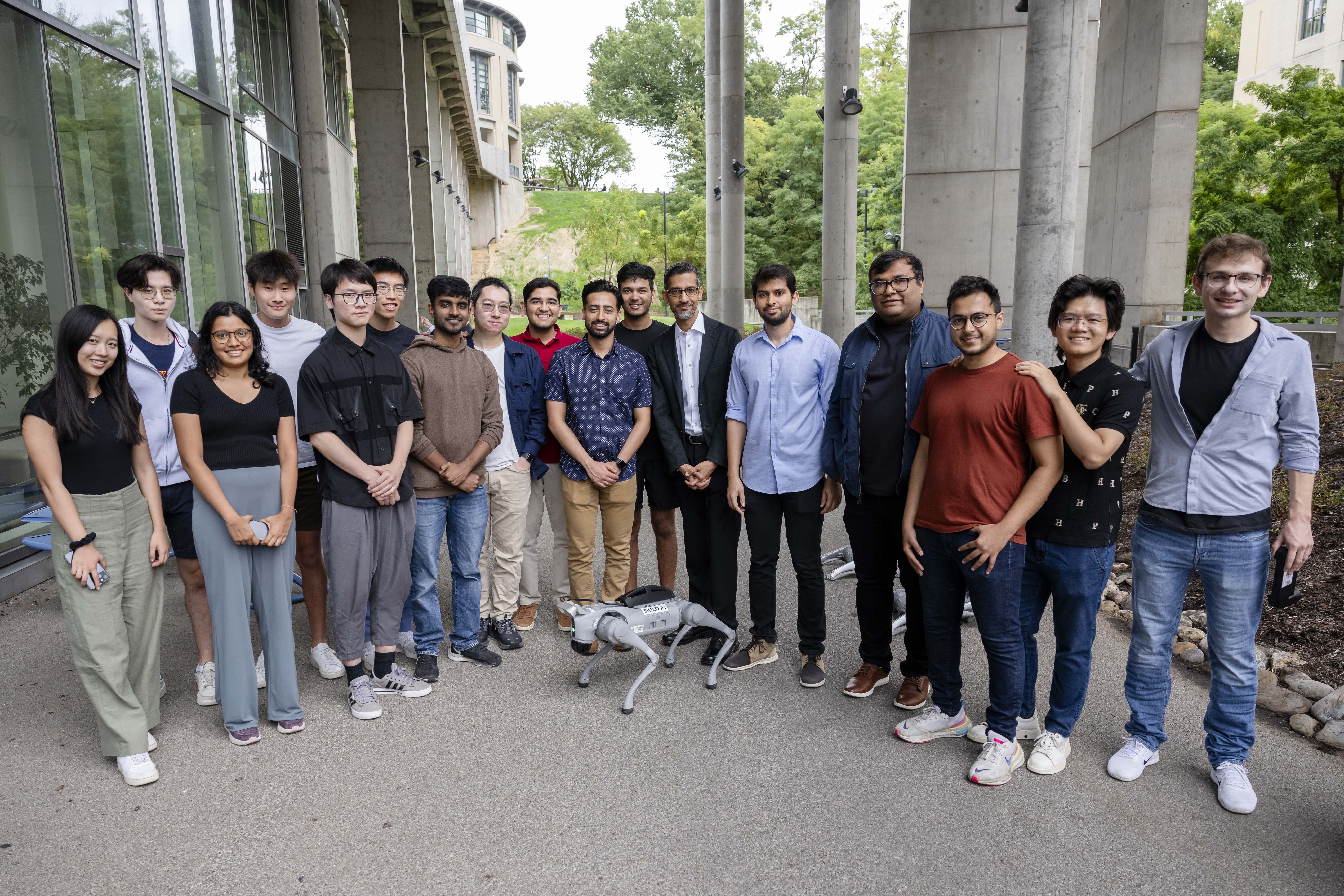Pichai with students, faculty, and a robot from Skild AI.