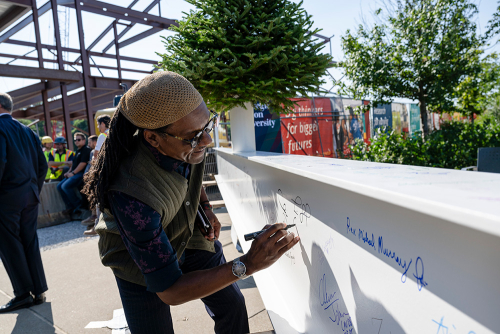 Pastor Tim Smith of Center of Life, Hazelwood, signs the community beam before being lifted and secured in place at the Robotics Innovation Center Topping Off Ceremony, 2024.