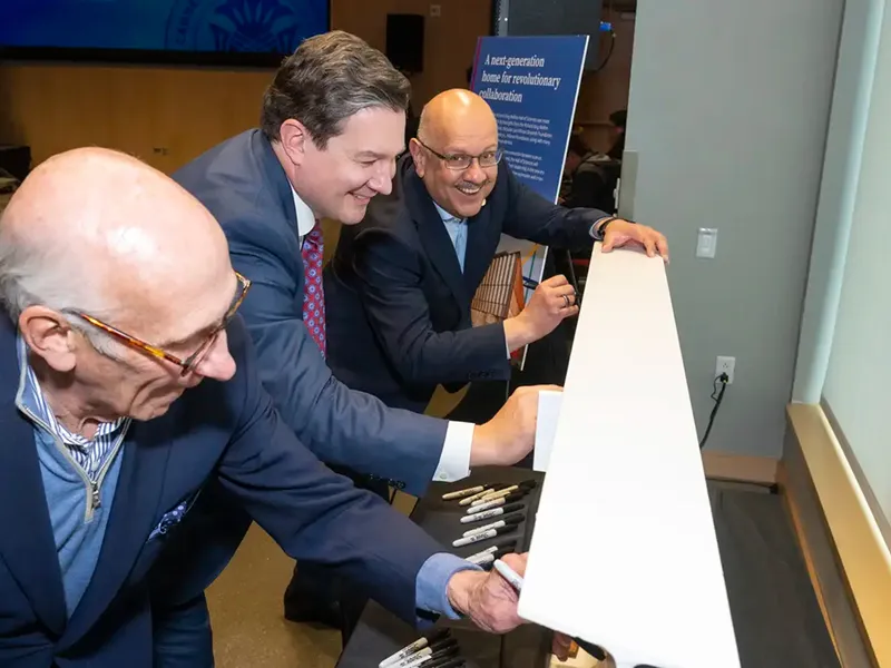 Chair of CMU's Board of Trustees David Coulter, Director of the Richard King Mellon Foundation Sam Reiman and CMU President Farnam Jahanian sign a beam for the Richard King Mellon Hall of Sciences, on Saturday, May 9, 2026, outside the Simmons Auditorium.