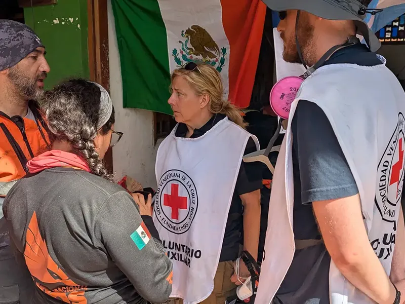 Kimberly Elenberg and Darwin Mick meet with members of the Venezuelan Red Cross, Mexico's Topos search and rescue team and other responders in La Guaira, Venezuela, to coordinate search operations following the June 24 earthquakes.