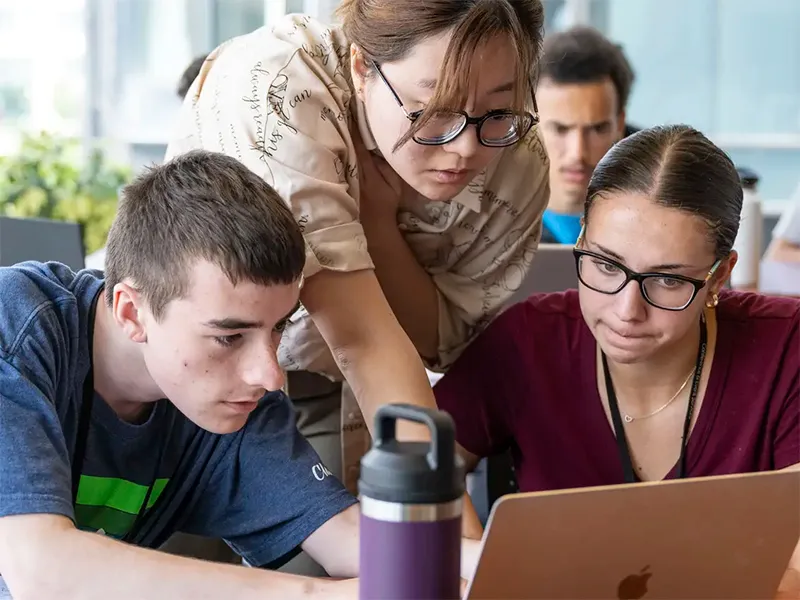 Carnegie Mellon pre-college students, working together around a laptop.