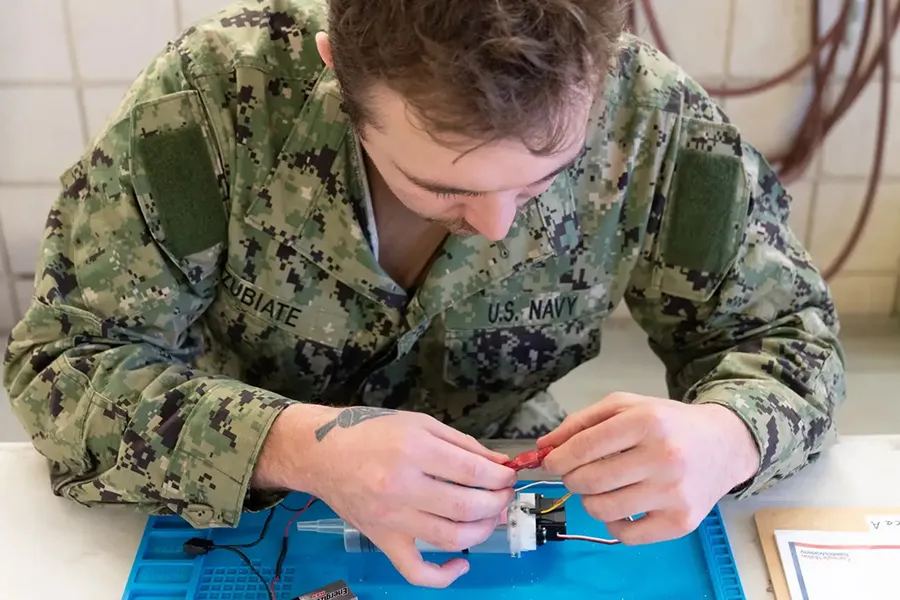 U.S. Navy sailor works in AI workshop.